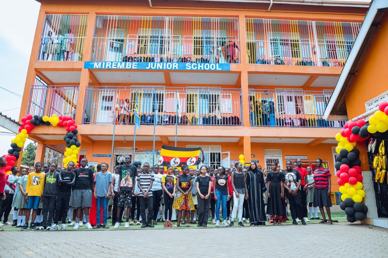 Staff and pupils gathered outside the Mirembe Junior School building during a school celebration